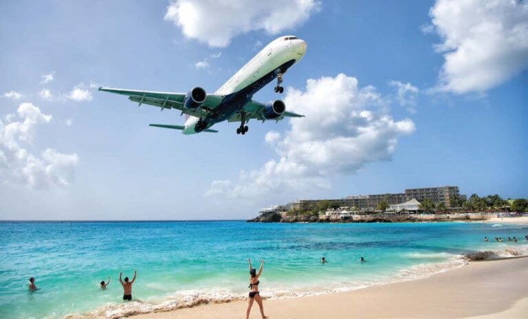 A widebody jet overflies the beach on short final to the runway at St. Maarten in the Caribbean. [Credit: Adobe Stock]