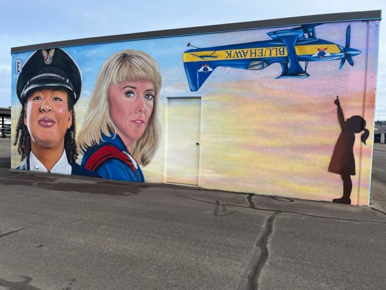 A mural to honor influential women aviators (Kimberly Scott Ford, left, and Joann Osterud) goes up at Auburn Municipal Airport near Seattle. [Credit: Meg Godlewski]