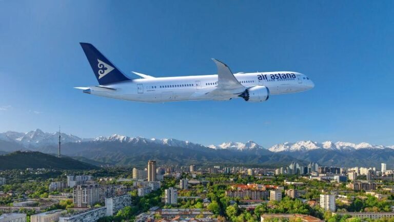 Boeing Air Astana aircraft flying over snowy mountains