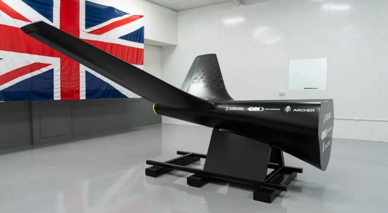 GKN joins Project NYX team for autonomous army platforms Aft fuselage and tail section of a black autonomous platform demonstrator bearing Anduril, GKN Aerospace and Archer logos, mounted on a test stand in front of a Union Jack flag