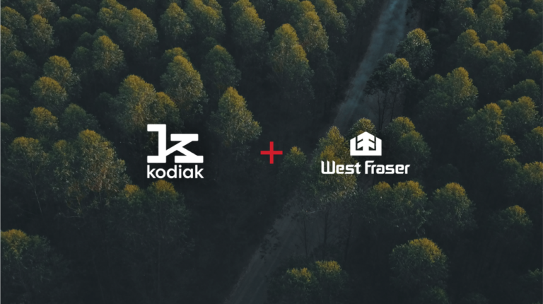 Kodiak AI announces autonomous trucking pilot in Canada Kodiak AI and West Fraser Timber logos on an image of Canadian forest.