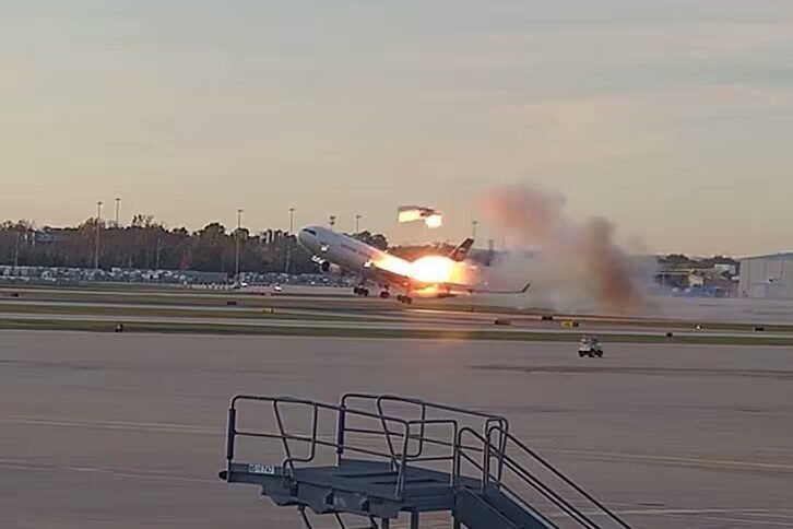 NTSB pulls dockets over cockpit audio concern Large passenger jet lifting off the runway with a bright exhaust flame and smoky plume trailing behind at sunset