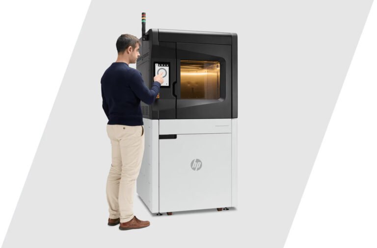 An operator monitoring Industrial Filament 3D Printer 600 HT through its built-in color touchscreen interface. Image via HP.
