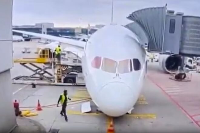 Locking pin found after Lufthansa 787 nose-gear collapse Front view of a white passenger airliner at the gate jet bridge connected and ground crew nearby on the tarmac