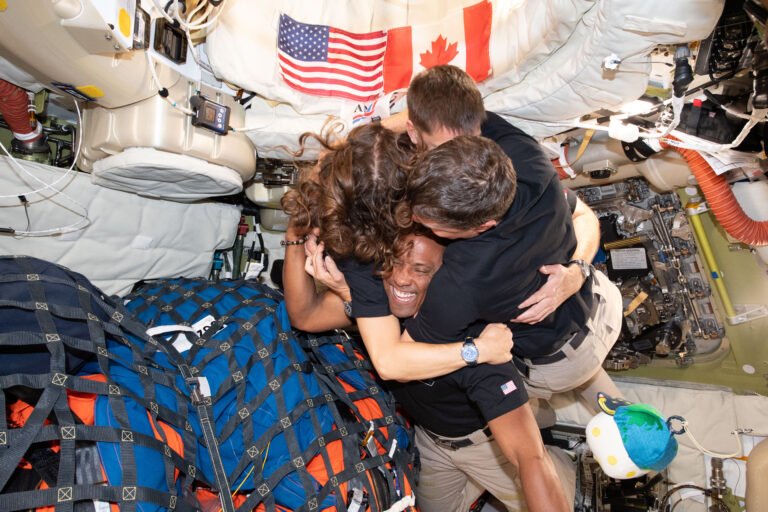 NASA’s Artemis II Breaks Agency Streaming Record art002e013367 (April 7, 2026) – The Artemis II crew – (clockwise from left) Mission Specialist Christina Koch, Mission Specialist Jeremy Hansen, Commander Reid Wiseman, and Pilot Victor Glover – take time out for a group hug inside the Orion spacecraft on their way home. Following a swing around the far side of the Moon on April 6, 2026, the crew exited the lunar sphere of influence (the point at which the Moon's gravity has a stronger pull on Orion than the Earth's) on April 7, and are headed back to Earth for a splashdown in the Pacific Ocean on April 10. The crew was selected in April 2023, and have been training together for their mission for the past three years.