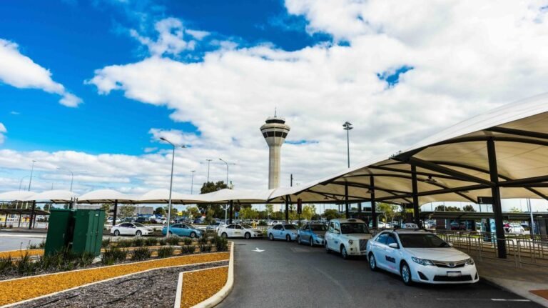 Perth Airport sets new annual passenger record in FY26 External front entrance to Perth Airport with a line of taxis and a blue sky with some clouds.