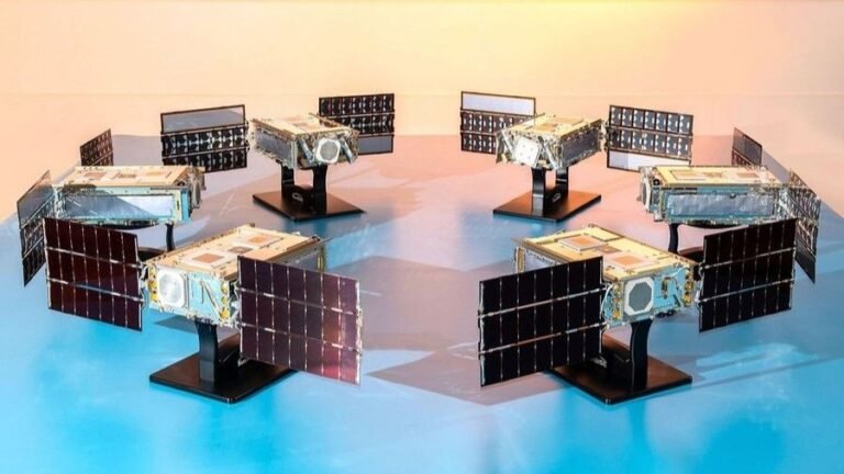 Vulcan Centaur swapped out again: NASA goes with SpaceX Falcon Heavy rocket for launch of space weather mission six small satellites with solar panels deployed stand in a circle on a table facing inward.