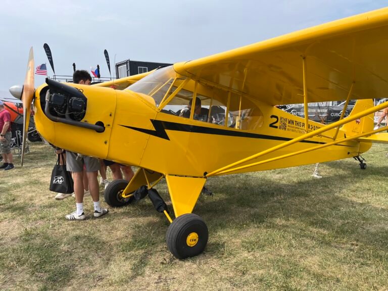 One of three J-3 Cubs being raffled off by the Jim Richmond Backcountry Aviation Foundation is on display at Oshkosh near the CubCrafters booth. [Credit: Meg Godlewski]