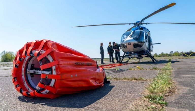 Polizeihubschrauber tragen Löschwasserbehälter Transall C-160D als Löschflugzeug beim Wasserabwurf