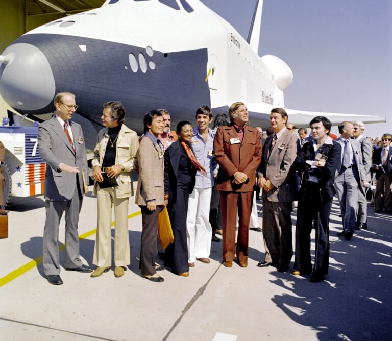 NASA Unveils Enterprise, the First Space Shuttle The Shuttle Enterprise (Orbiter Vehicle 101) rolls out of the Palmdale manufacturing facilities with Star Trek television cast members. From left to right they are: Dr. James D. Fletcher, NASA Administrator, DeForest Kelley (Dr. "Bones" McCoy), George Takei (Mr. Sulu), James Doohan (Mr. Scott), Nichelle Nichols (Lt. Uhura), Leonard Nimoy (the indefatigable Mr. Spock), Gene Rodenberry (The Great Bird of the Galaxy), and Walter Koenig (Ensign Pavel Chekov).