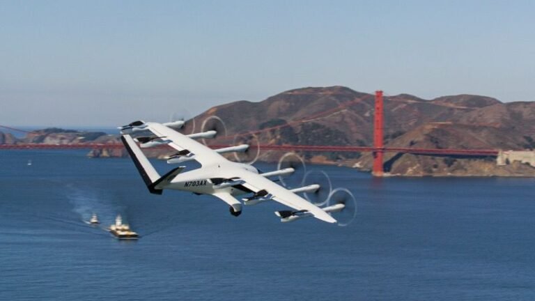 Archer’s white Midnight air taxi, registration N703AX, in forward flight over San Francisco Bay with the Golden Gate Bridge behind