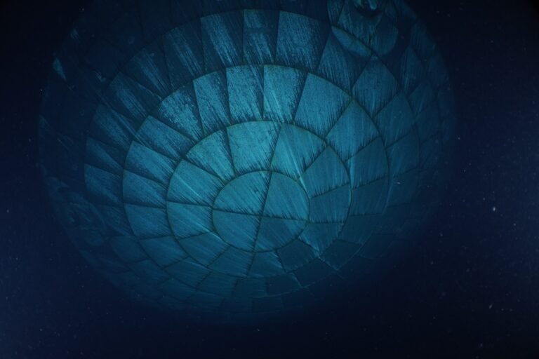 The Orion spacecraft's heat shield dominates this underwater photo. Due to the water, the heat shield appears to be teal-colored.
