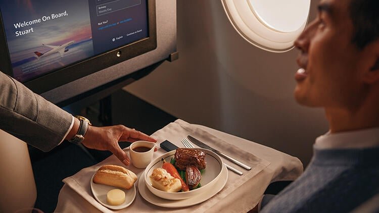 Delta Air Lines And United Airlines Lead New Wave Of Unbundling inflight meal being served to passenger