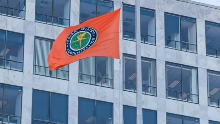FAA Breaks ATC Hiring Record, But More Work Remains Flag with FAA logo in front of a building