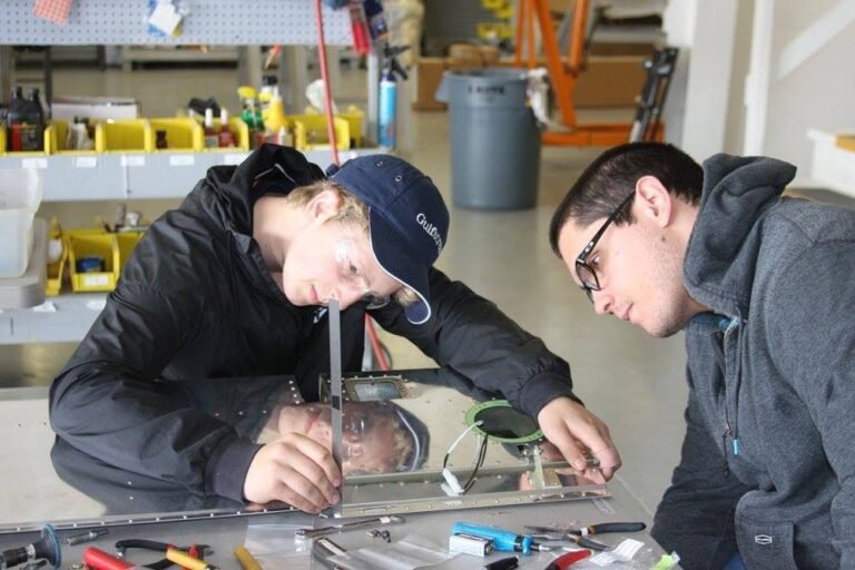 High school students work on an airplane wing.[Credit: GAMA]